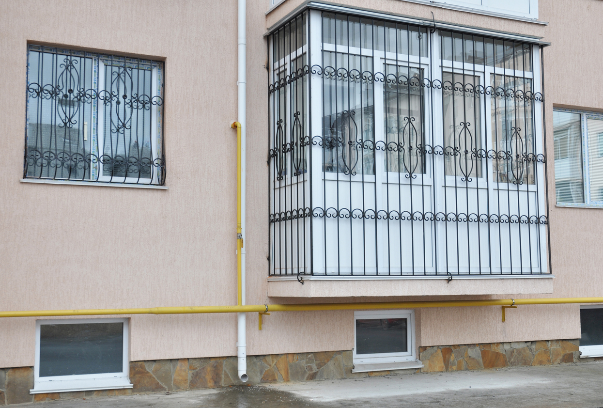 window-burglar-bars-or-security-grills-to-protect-the-home-the-window-and-balcony-of-the-residential-apartment-on-the-ground-floor-with-metal-security-bars-and-guards-installed