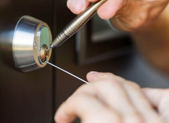 Emergency locksmith using picks to unlock a door